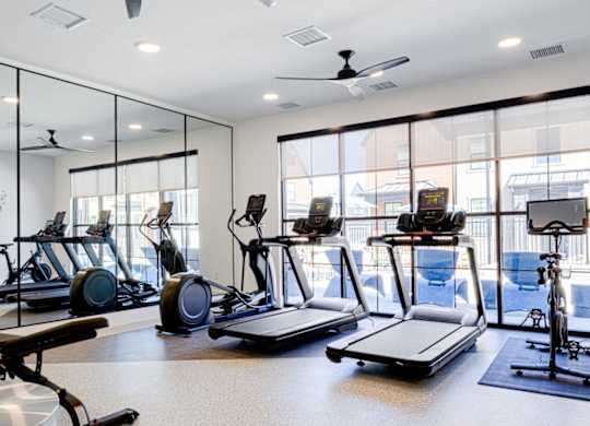 A gym with treadmills, exercise bikes, and elliptical machines.