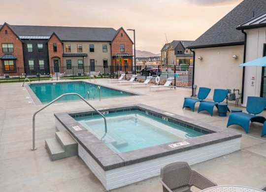 A hot tub sits in the middle of a patio with chairs around it.