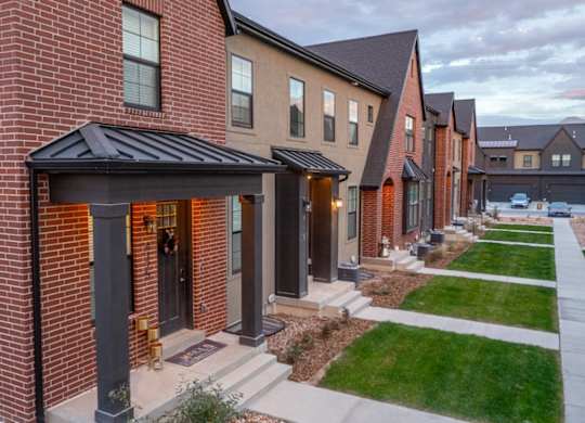 A row of houses with a red brick house in the front.