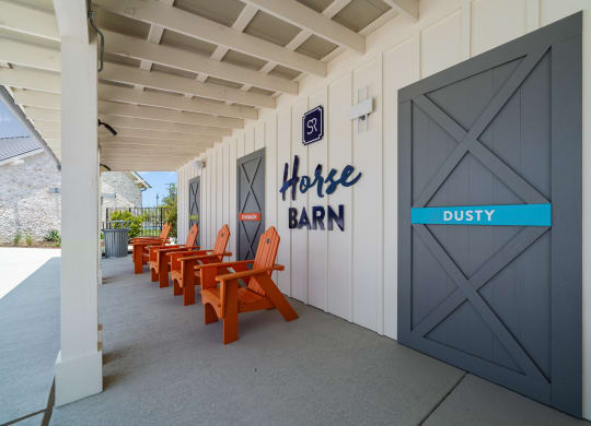 a row of orange chairs outside of a building with a door to a coffee barn