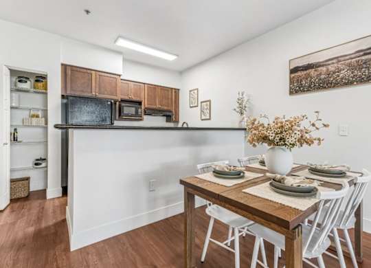 A dining room with a wooden table set for four.
