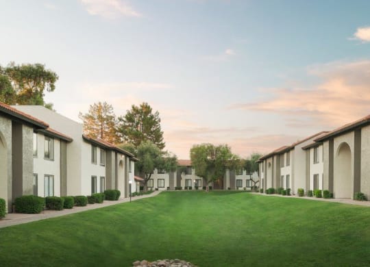 a green lawn in front of a row of houses