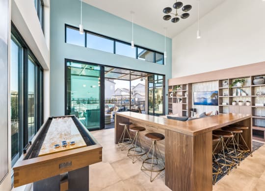 Marlette bar with a shuffleboard table in a room with glass doors