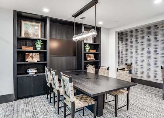 A modern dining room with a dark wood table and chairs.