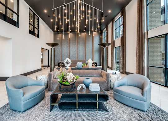 A modern living room with a grey sofa, a coffee table, and a large window.