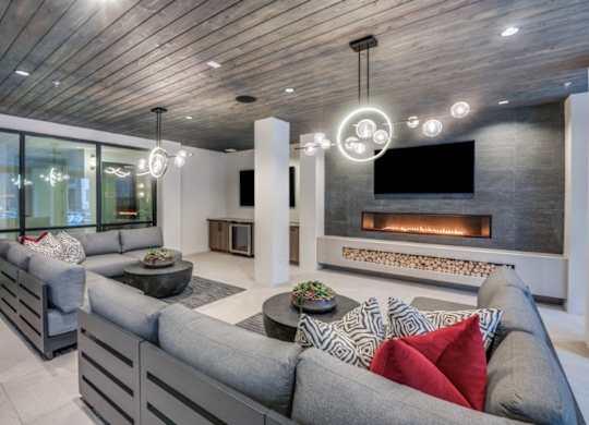 A modern living room with a grey sofa and a fireplace.