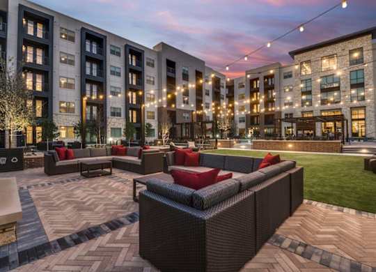 A modern outdoor seating area with red cushions and a patterned floor.