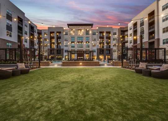 A large grassy area in front of apartment buildings.