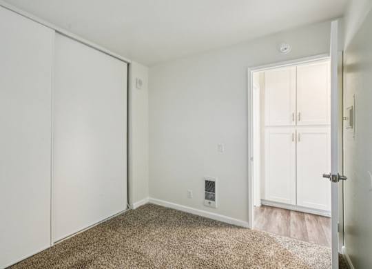 A room with a carpeted floor and a sliding door.