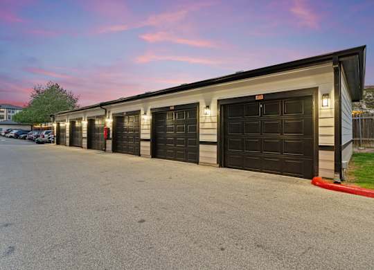 A long building with black garage doors.