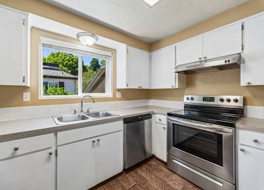 A kitchen with white cabinets and stainless steel appliances.