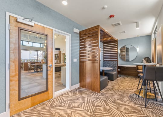 a lobby with a bar and a dining room with a table and chairs