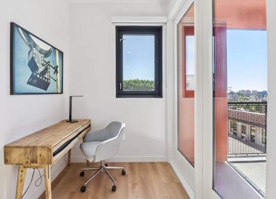 A room with a desk and chair with a window.