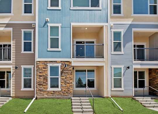 A modern apartment building with a blue, beige, and brown facade.