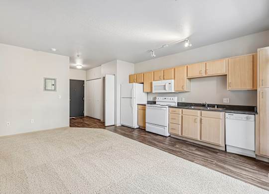 A kitchen with white appliances and wooden cabinets.