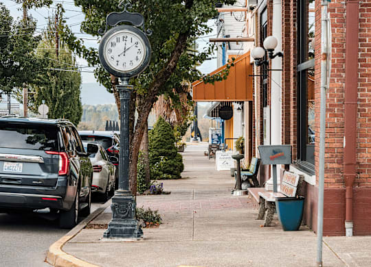 A street scene with a clock post in the foreground.