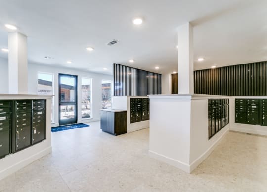 the inside of a building with a reception desk and mailboxes