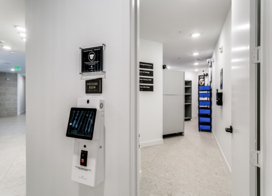 the hallway of a building with a white wall and electronics on it