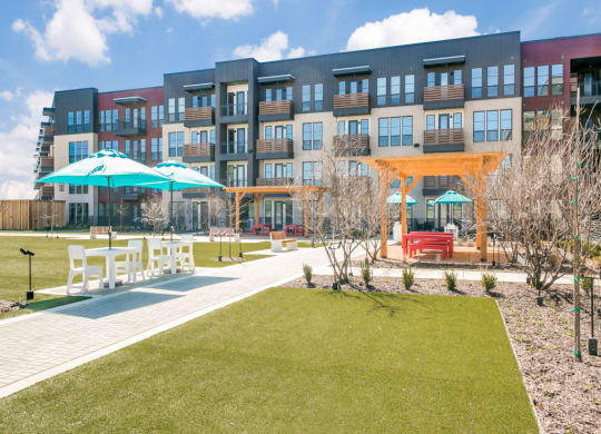 a building with a lawn and umbrellas in front of it
