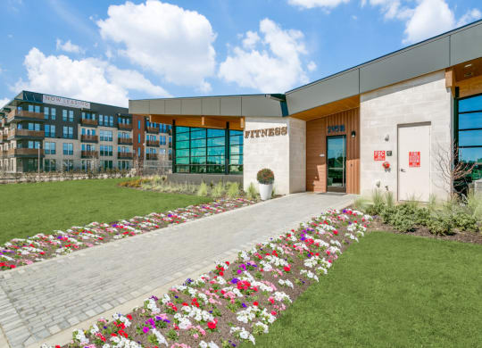 a building with a lawn and flowers in front of it