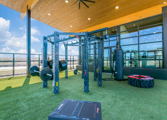 a gym with weights and other equipment on the grass