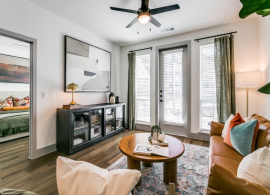 a living room with a couch and a coffee table and a ceiling fan