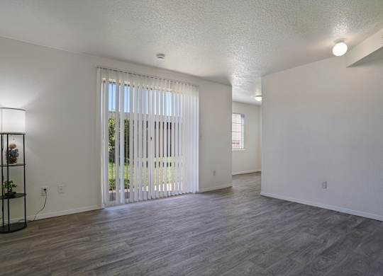 A room with a sliding glass door and a wooden floor.