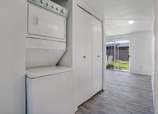 A white fridge in a room with a door open.