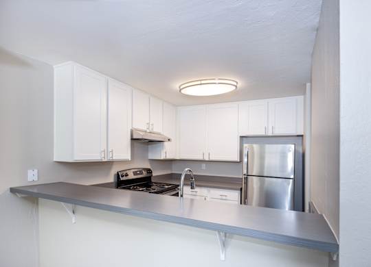 A modern kitchen with stainless steel appliances and white cabinets.