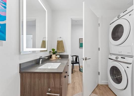 A small, modern kitchen with a washing machine in the doorway.