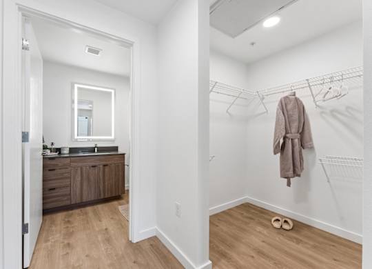 A bathroom with a wooden vanity and a towel hanging on the wall.