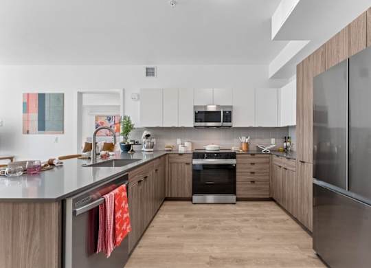 A modern kitchen with wooden cabinets and stainless steel appliances.