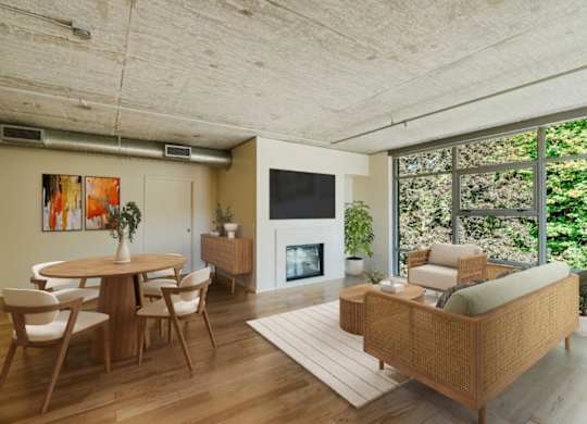 Living room and dining room space with large windows and wood-style flooring at 2121 Belmont apartments in the Buckman neighborhood in Portland, Oregon.