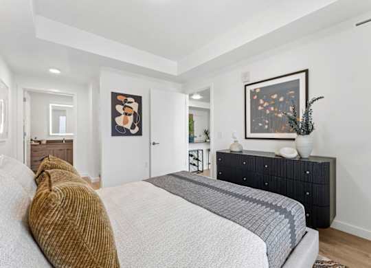 A bedroom with a large bed and a painting on the wall.