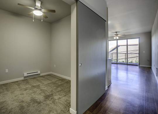 A room with a ceiling fan and a window.