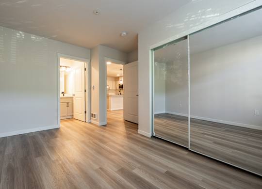 A room with a white wall and a wooden floor.
