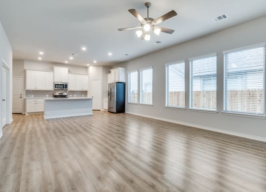 an open living room and kitchen with a ceiling fan