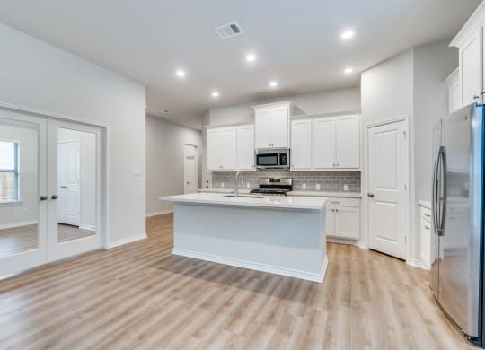 an open kitchen with white cabinets and a white counter top