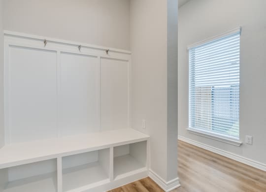 an empty room with white closets and a window