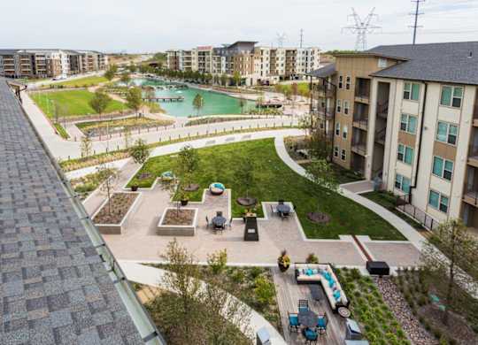 A rooftop view of a residential area with a pool and apartment buildings.