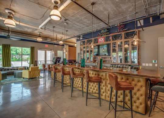 A bar with a row of stools in front of it.