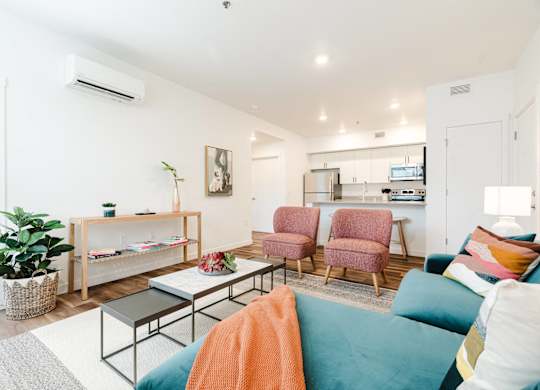 A living room with a couch, chairs, and a coffee table.