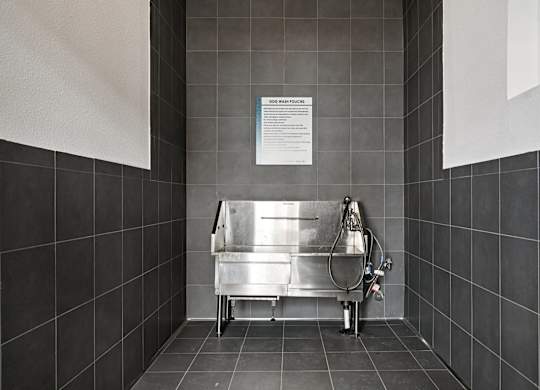 A sink in a public restroom with a sign above it.
