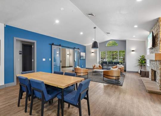 A modern dining room with a wooden table and blue chairs.