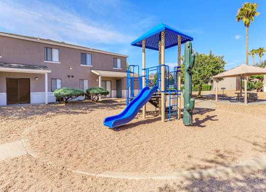 A playground with a blue slide and a green slide.