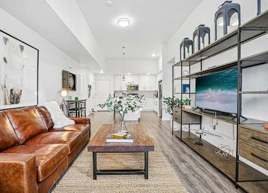 A living room with a brown leather couch and a wooden coffee table.