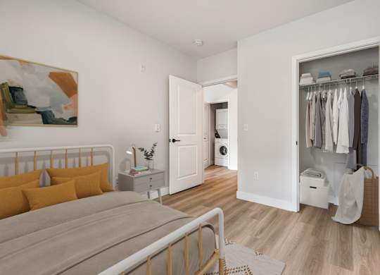 A bedroom with a bed, nightstand, and a painting on the wall.