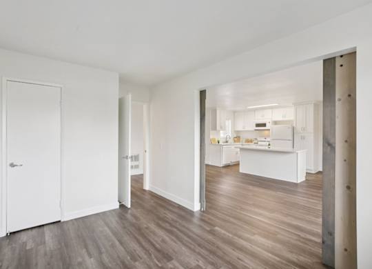 A white interior with a kitchen in the distance.