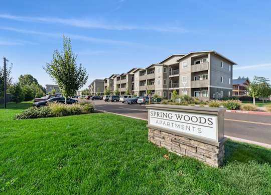Spring Woods Apartments sign in front of apartment building.