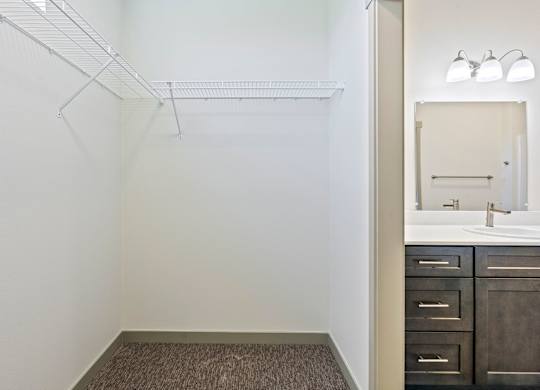 A bathroom with a sink, mirror, and a shelf.